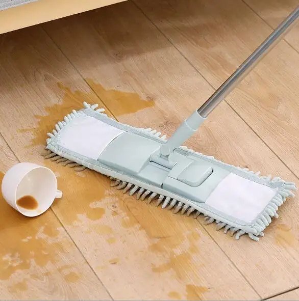 Grey chenille pad on a flat mop wiping up spilt coffee on a wooden floor