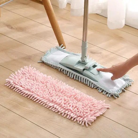 Hand pressing a chenille pocket pad onto the flat mop frame beside a pink spare pad