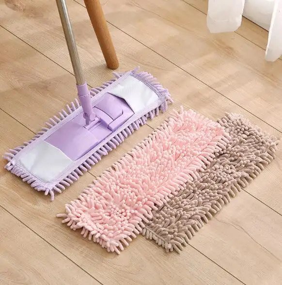 Purple chenille flat mop on a wooden floor with pink and brown spare pads