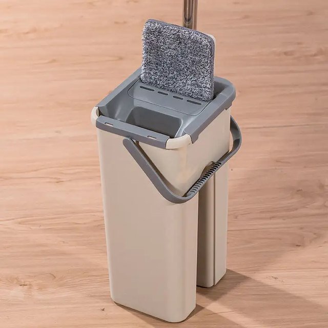 Microfiber pad of the flat mop standing in the squeeze slot of the bucket lid