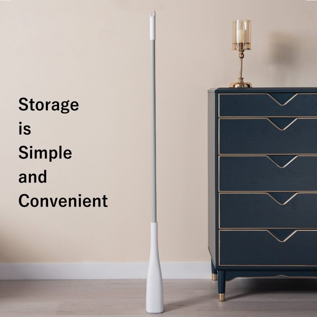 Sponge mop with head retracted, leaning against a wall beside a cabinet