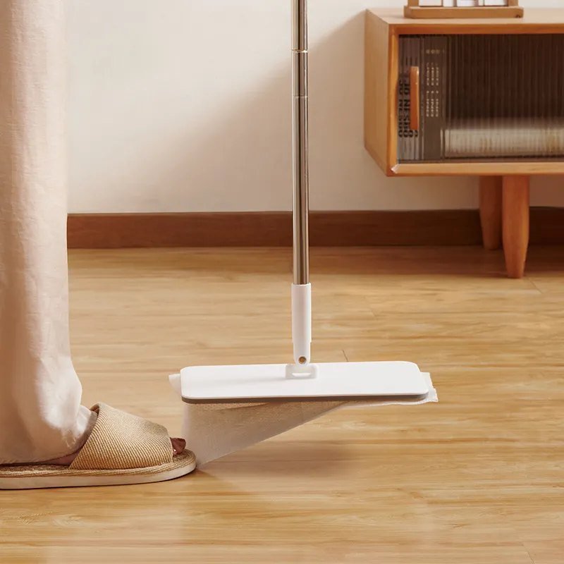 Flat mop head swivelled upright to clean the floor round a foot