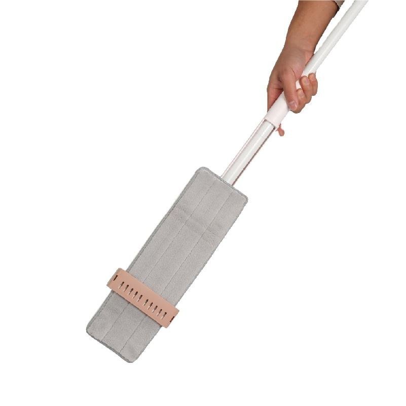 Grey microfiber pad of the flat mop held upright inside the pink wringing collar