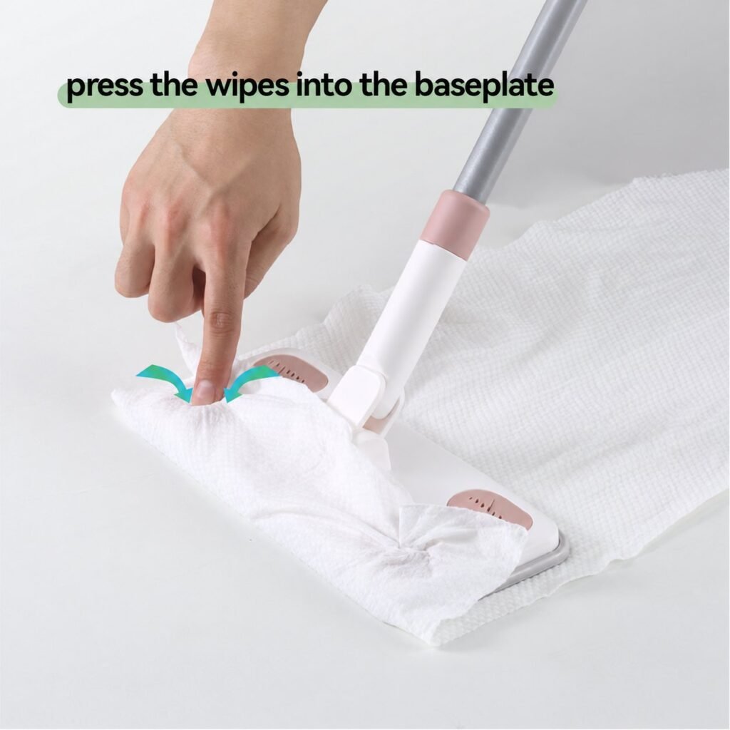 Finger pressing a white wipe into a grip on the flat mop baseplate