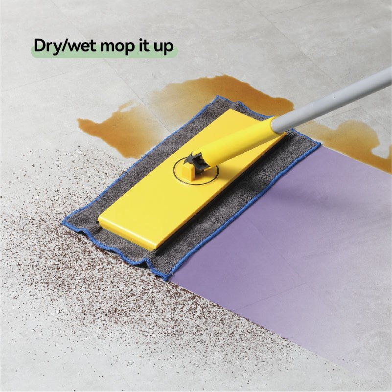 Yellow flat mop with grey cloth wiping dirt and a spill from a grey tiled floor