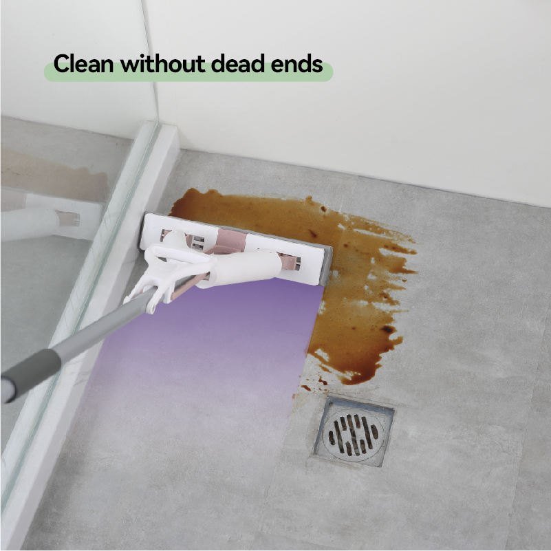 Fold-squeeze sponge mop with pink trim wiping a coffee spill on a grey bathroom floor