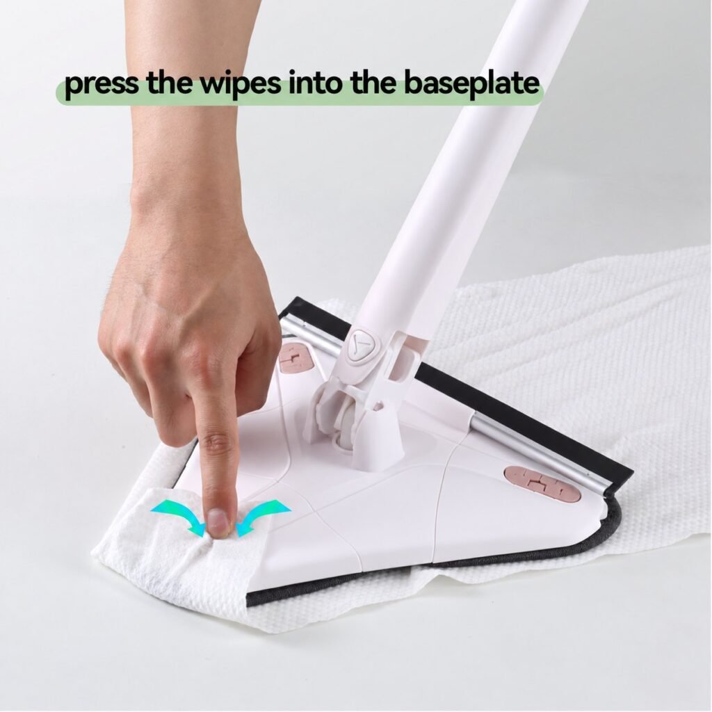 Hand pressing a disposable wipe into the baseplate of the triangle mop head