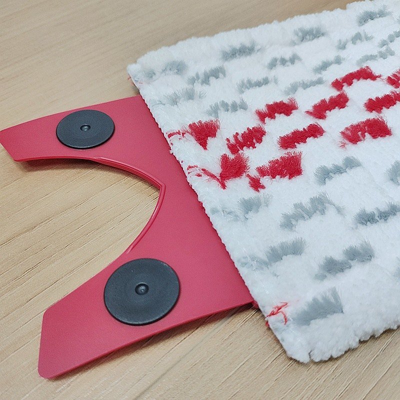 Close-up of the red rubber tab with two black snaps on the microfiber pad