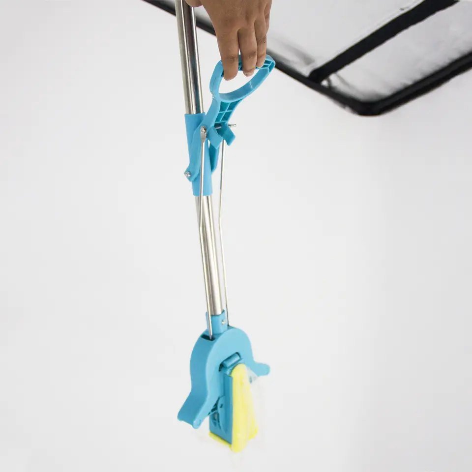 Hand lifting the ring lever so the PVA sponge folds and is squeezed in the head