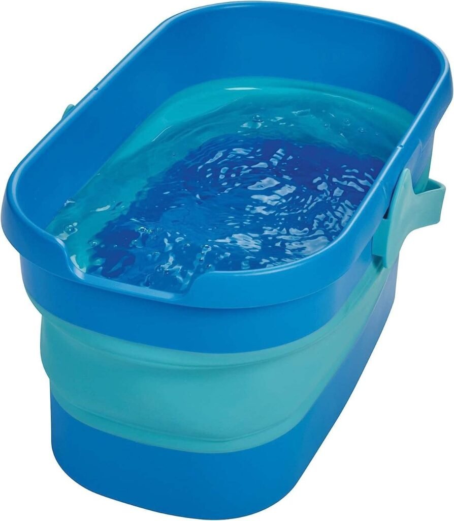 Collapsible blue bucket opened up and filled with water, carry handle at the side