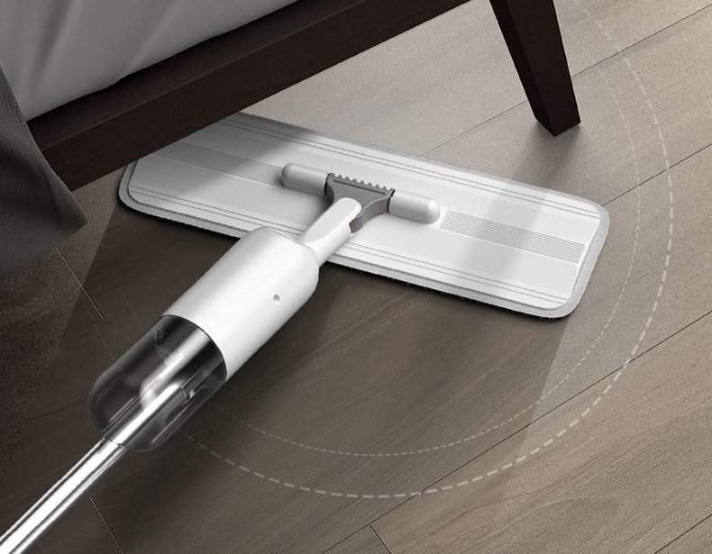 Slim head of the white spray mop sliding under a bed frame